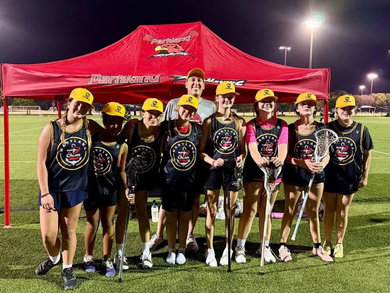 Redhawks girls team under the red tent at night